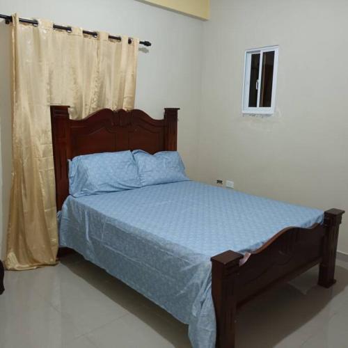 a bedroom with a bed with a blue comforter at Apto. a 3 minutos de la playa. Aire FULL in Azua de Compostela
