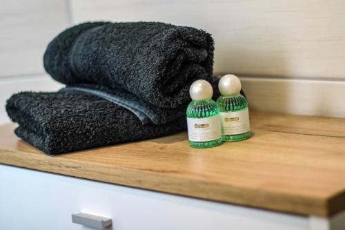 a black towel and two bottles on a wooden shelf at Chill Out Area, Sauna & Wirlpool, grandiose Aussicht, Smart TV, Netflix in Zell an der Mosel