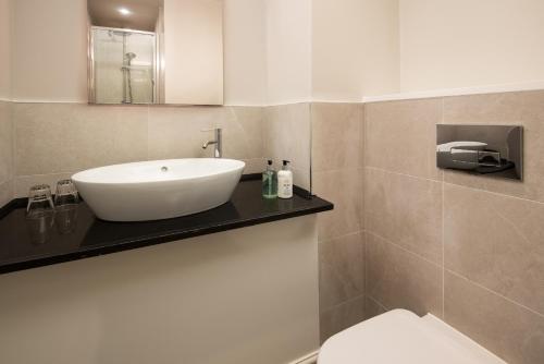 a bathroom with a white sink and a toilet at Windermere Rooms at The Wateredge Inn in Ambleside