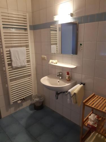 a bathroom with a sink and a mirror at City-Hotel-Pension-Grafenwöhr in Grafenwöhr