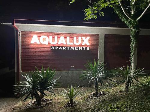 a sign on a building with plants in front at Aqualux Apartments in Star Dojran