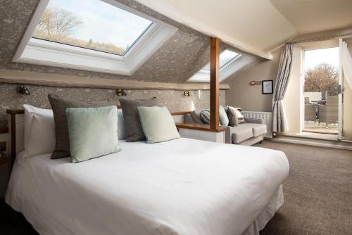 a bedroom with a large white bed with windows at Windermere Rooms at The Wateredge Inn in Ambleside
