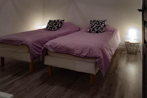 - 2 lits dans une chambre avec des draps et des oreillers violets dans l'établissement La Frégate, au Tréport