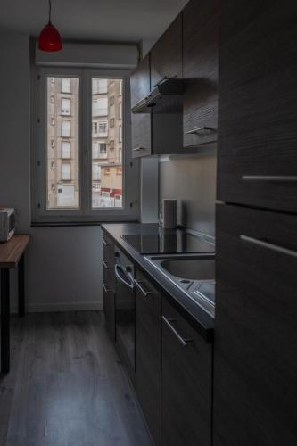 d'une cuisine équipée d'appareils en acier inoxydable et d'une fenêtre. dans l'établissement La Frégate, au Tréport