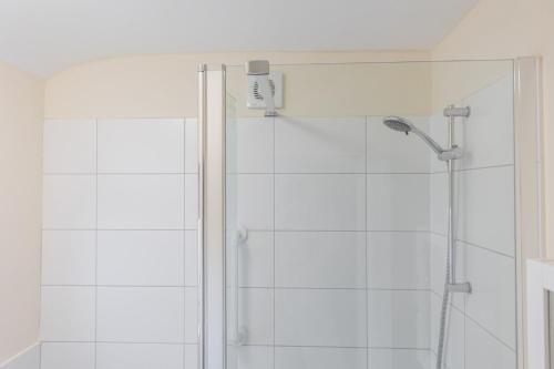 a shower with a glass door in a bathroom at Albany Cottage in Southwold