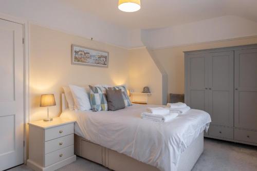 a bedroom with a white bed with towels on it at Albany Cottage in Southwold