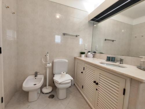 a white bathroom with a toilet and a sink at Albufeira Balaia Golf Vilage 4 With Pool by Homing in Albufeira