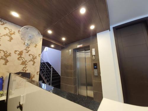 a bathroom with a mirror and a staircase with a elevator at New Gokul Grand in Dehradun
