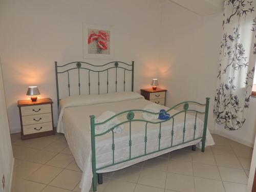 a bedroom with a bed and two nightstands with two lamps at Meraviglioso appartamento sul porto in Santa Maria Navarrese
