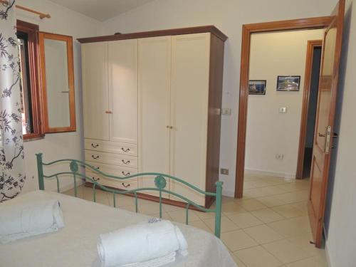 1 dormitorio con 1 cama, vestidor y armario en Meraviglioso appartamento sul porto, en Santa Maria Navarrese