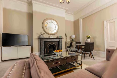 un soggiorno con divano e camino di Luxury Apartment - 18 Lansdown Crescent a Cheltenham