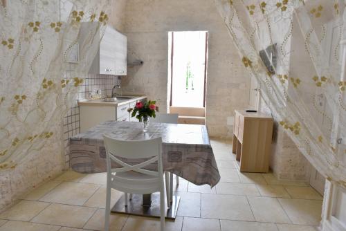 a kitchen with a table with a vase of flowers on it at Agape fra i Trulli Dimora Orchidea in Alberobello