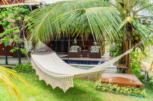 a hammock in a garden next to a pool at Casa em Condomínio/ Piscina Churrasqueira privativas / Frente ao Mar / Gostoso RN in São Miguel do Gostoso