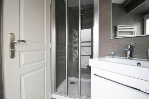 une salle de bain avec une douche, un lavabo et un miroir dans l'établissement Paris, Opéra 1... Comme chez soi, à Paris