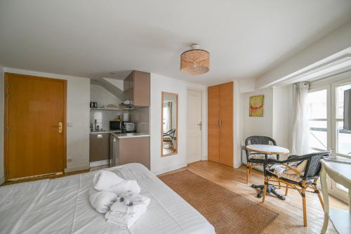 Cet appartement comprend une chambre avec un lit blanc et une cuisine. dans l'établissement Paris, Opéra 1... Comme chez soi, à Paris
