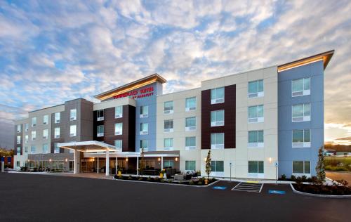 an exterior view of a hotel with a cloudy sky at TownePlace Suites Portland Airport ME in South Portland