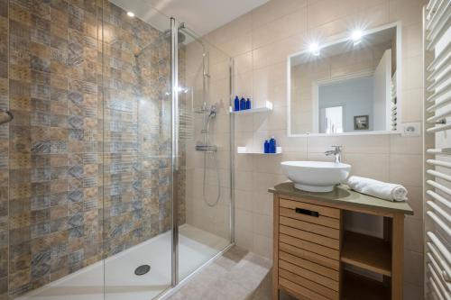 une salle de bain avec un lavabo et une douche dans l'établissement Le Méditerranée - Charmant 3 pièces au coeur du centre ville de Menton, à Menton