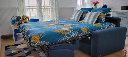 une chambre avec un lit bleu et une chaise bleue dans l'établissement DISNEYLAND PARIS - VAL D'EUROPE - PARKING - WIFI, à Serris