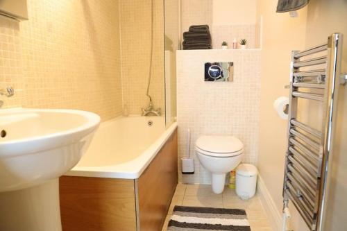 a bathroom with a white sink and a toilet at Modern flat Tower Bridge/Bermondsey in London