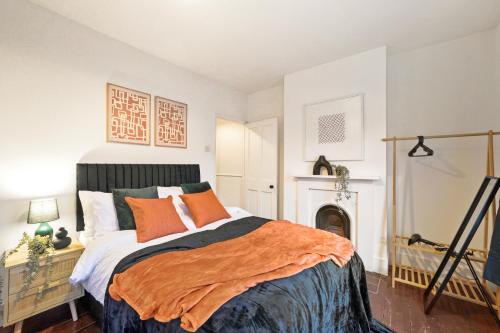 een slaapkamer met een bed met een oranje deken bij Boutique London Abode - Games Room - Parking in Plumstead