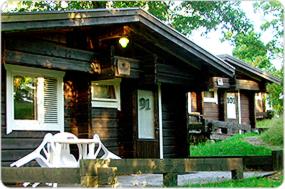 a small house with a white bench in front of it at Tallhöjden Hotel & Cottage Lodge in Simlångsdalen