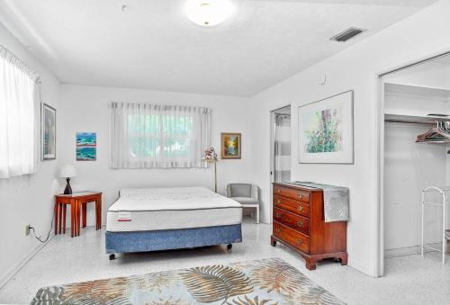 a bedroom with a bed and a dresser in it at Cozy cottage for longer stays! in Vero Beach