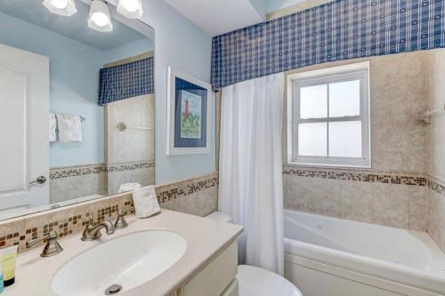 La salle de bains est pourvue d'un lavabo, de toilettes et d'une baignoire. dans l'établissement Lazy Pelican: Walk to beach, indoor pool, à Tybee Island