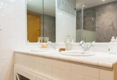 uma casa de banho com 2 lavatórios e um espelho grande em Comodidad en primera linea de playa em Benalmádena