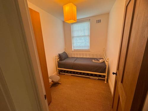 a small bedroom with a bed and a window at A beautiful gem in North London in Colindale