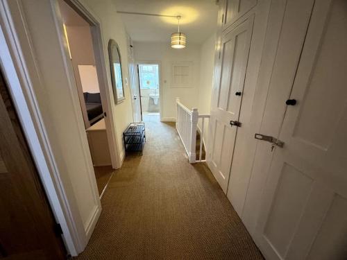 a hallway with a white door and a stairway at A beautiful gem in North London in Colindale