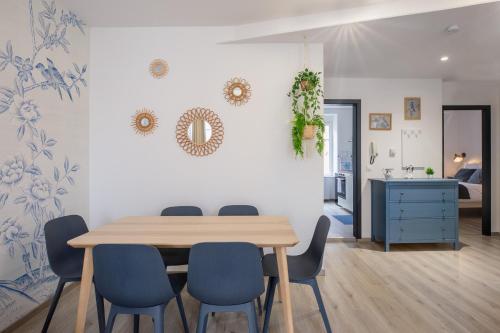 une salle à manger avec une table et des chaises bleues dans l'établissement Travel Homes - Niffel 3 - Un havre de paix près du Parc, à Mulhouse