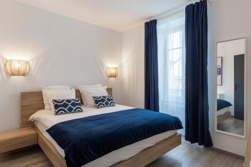 une chambre avec un lit avec des oreillers bleus et blancs dans l'établissement Travel Homes - Niffel 3 - Un havre de paix près du Parc, à Mulhouse