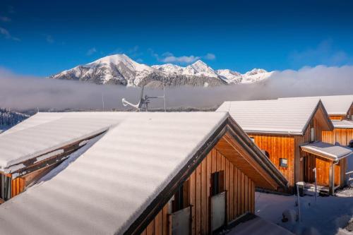 a building with snow covered roof with mountains in the background at Chalet in Hohentauern - Chalet Ana in Hohentauern