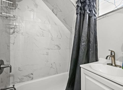 a bathroom with a shower curtain and a sink at St Paul Fry Street Den Tower Suite #3 in Saint Paul