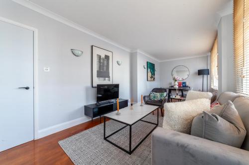 a living room with a couch and a table at Cosy Apartment Steps From London Eye in London