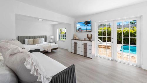 a white bedroom with two beds and a pool at Villa Seabreeze in Fort Lauderdale