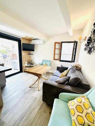 un salon avec un canapé et une table dans l'établissement Maison de village à 10 min d'Ile Rousse, à Santa-Reparata-di-Balagna