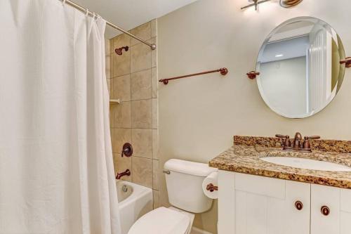 La salle de bains est pourvue de toilettes, d'un lavabo et d'un miroir. dans l'établissement Beach Breeze, Walk to beach, pool access, à Tybee Island