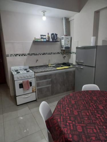 a kitchen with a stove and a refrigerator and a table at Monoambiente Confortable Tucuman in San Miguel de Tucumán