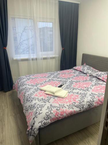 een slaapkamer met een bed met een boek erop bij TwinsHause in Craiova