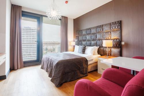 - une chambre avec un lit et deux chaises rouges dans l'établissement Lux Residence w Balcony 1 min to Metro in Merter, à Istanbul
