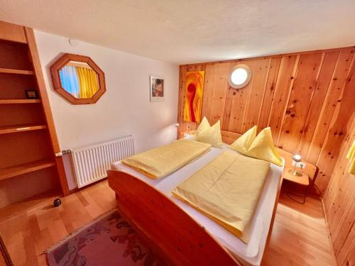 1 dormitorio con 1 cama en una habitación con paredes de madera en Haus Kogler en Aich