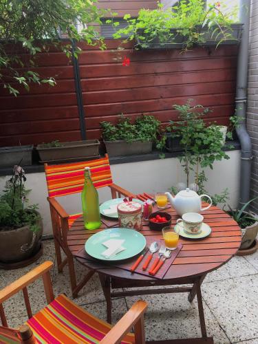 une table en bois avec des assiettes de nourriture dessus dans l'établissement Appartement COSY 3 pièces Paris 18e Montmartre Parking & Terrasses, à Paris