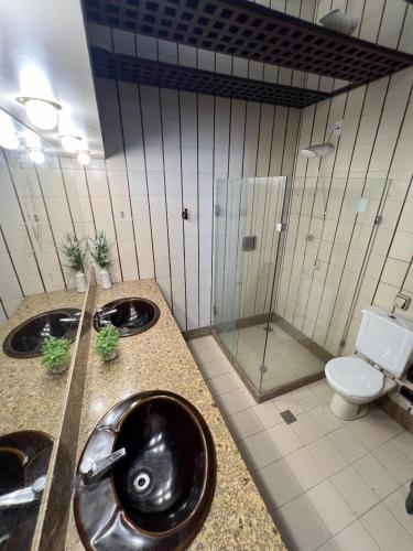a bathroom with a sink and a toilet and a shower at Pousada Mangai in João Pessoa