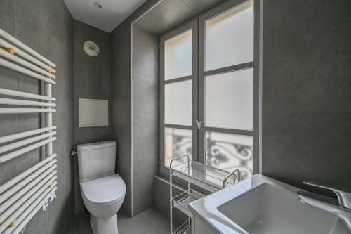 une salle de bain avec toilettes, lavabo et fenêtre dans l'établissement Paris, Opéra 4...So parisian Apartment, à Paris