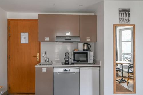 une cuisine avec un micro-ondes et une cuisinière four supérieur dans l'établissement Paris, Opéra 4...So parisian Apartment, à Paris