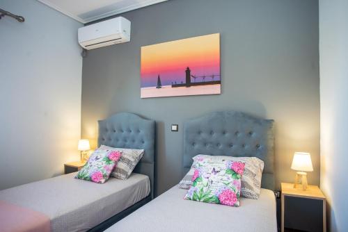 a bedroom with two beds and a picture on the wall at Irida's house in Kefallonia