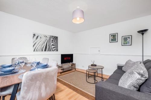 a living room with a table and a couch at 4 Bedroom House with Parking & Garden by Cherry Inn Short Let's & Services Accomodation in Cambridge