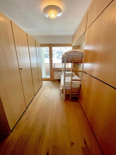 Zimmer mit einem Etagenbett und Holzschränken in der Unterkunft Cozy apartment in St. Moritz in St. Moritz