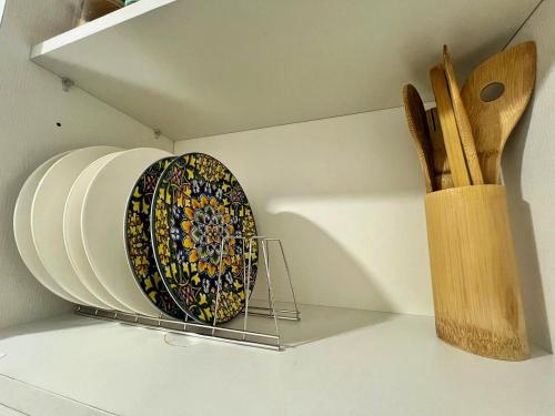 a plate on a shelf next to a knife block at KPlace Staycation at Azure North in San Fernando